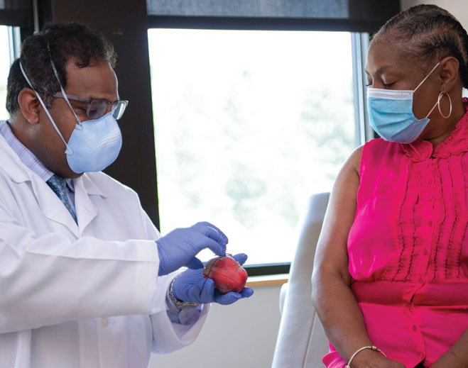 doctor showing patient a model heart