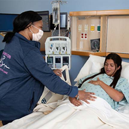 nurse helping pregnant patient